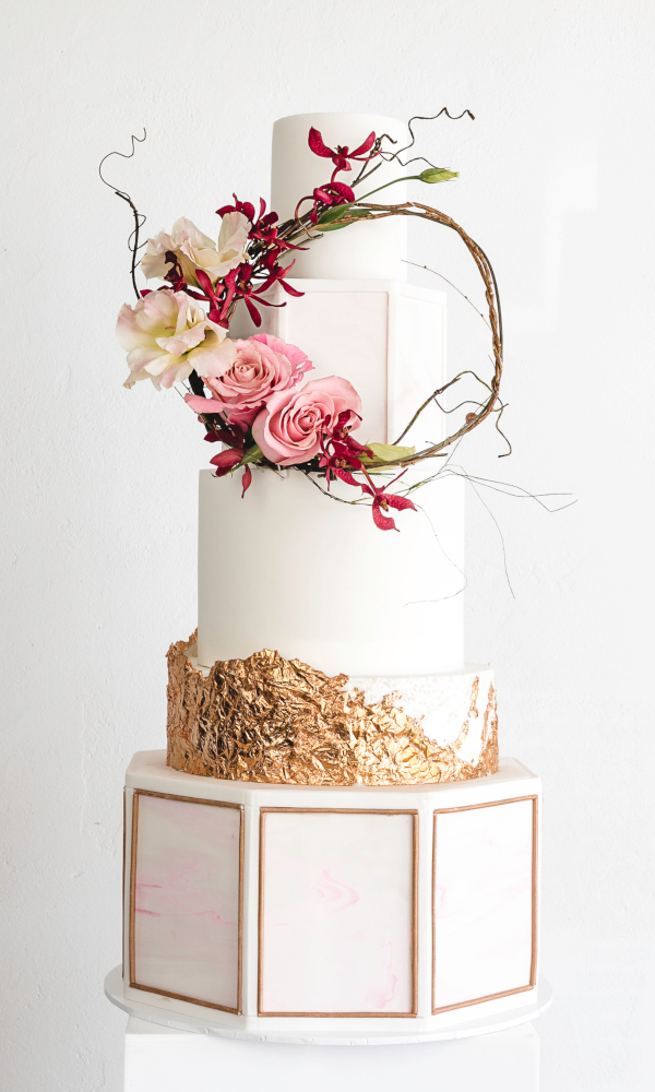 5 tier pink marble and rose gold octagonal wedding cake with whimsical flower wreath